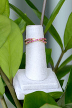 Two rings on a white stand surrounded by green leaves