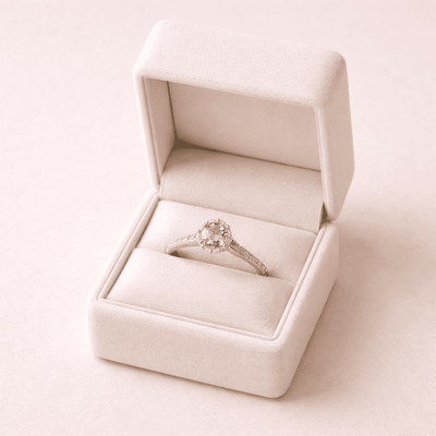 Finished custom gemstone ring displayed in an elegant jewelry box on a soft pink background