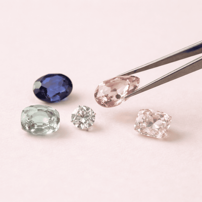 Loose gemstones arranged with tweezers for selecting stones for a custom jewelry design